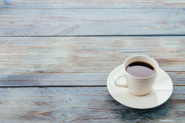 Koffiekopje op houten tafel — Stockfoto