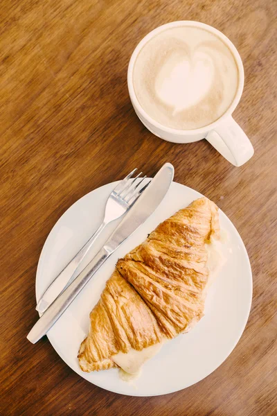 Croissant with coffee cup — Stock Photo, Image