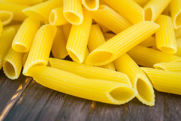 Raw pasta on wooden background — Stock Photo, Image