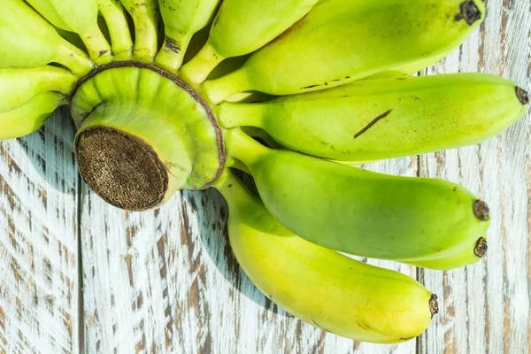 Grüne Banane auf Holzgrund — Stockfoto