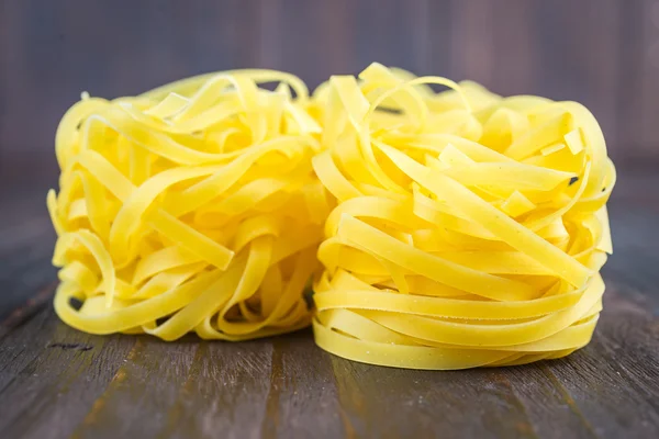 Pasta cruda sobre fondo de madera — Foto de Stock