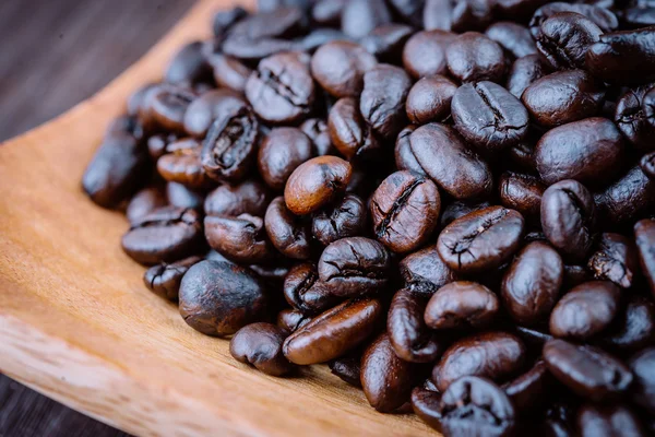 Koffiebonen op houten ondergrond — Stockfoto