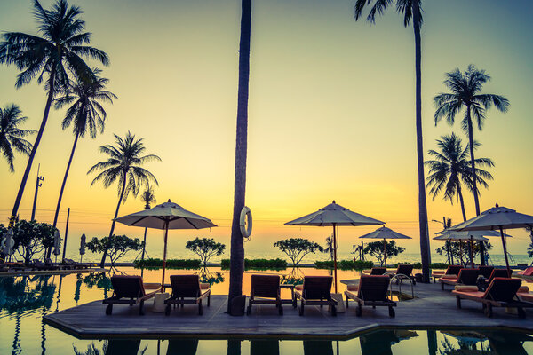 Sun loungers with umbrellas at pool