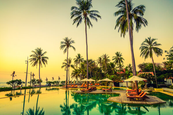 Sun loungers with umbrellas at pool