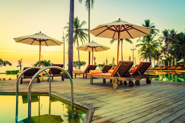 Sun loungers with umbrellas at pool