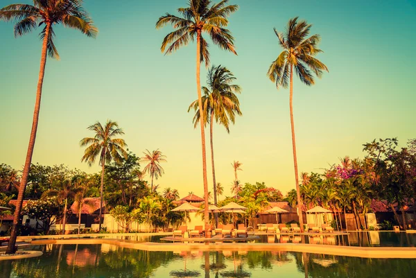 Sun loungers with umbrellas at pool — Stock Photo, Image