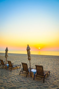 Plaj sandalyesini gündoğumu ile
