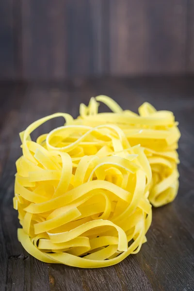Raw pasta on wooden background — Stock Photo, Image