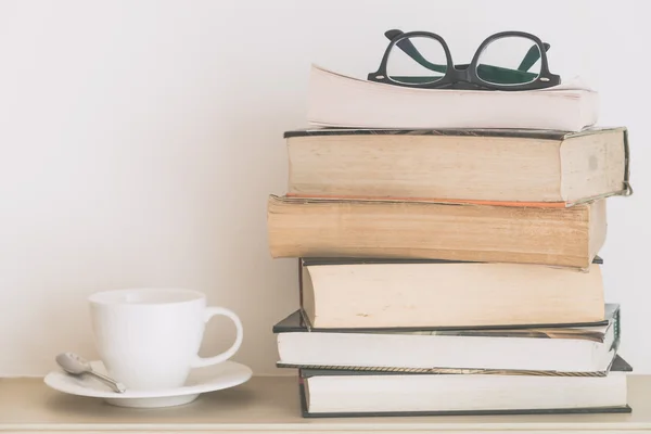 Koffiekopje met boeken en brillen — Stockfoto