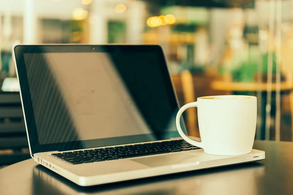 Laptop en koffie beker — Stockfoto