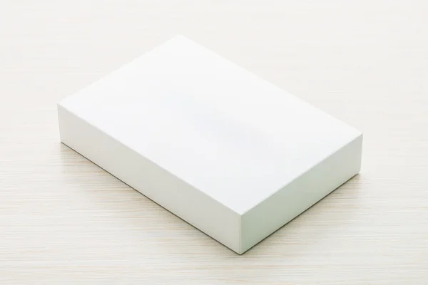 Белая коробка на деревянном фоне Стоковое Изображение