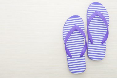 Tahta arka planda parmak arası terlikler