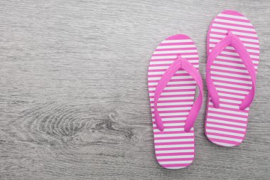 Tahta arka planda parmak arası terlikler