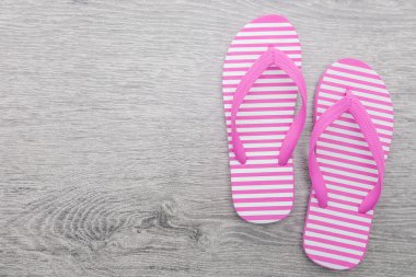 Tahta arka planda parmak arası terlikler