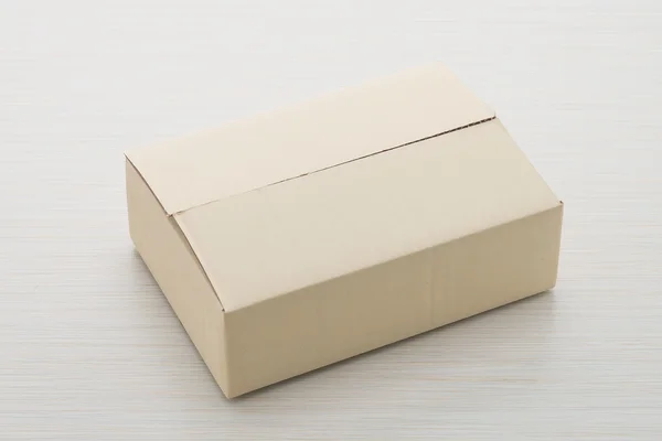 Паперова коробка на фоні дерева — стокове фото