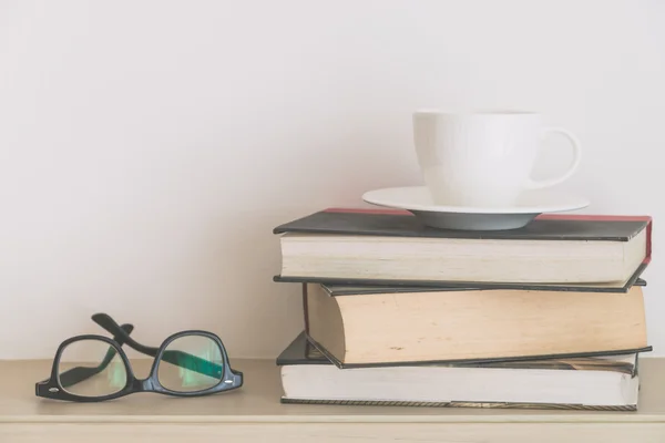 Koffiekopje met boeken en brillen — Stockfoto