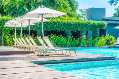 Şemsiyeleri ve sandalyeler otel havuzu tesisi