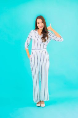 Asyalı güzel bir kadının portresi mavi izole edilmiş arka planda gülümsüyor.