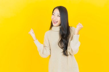 Portre güzel Asyalı kadın gülümsüyor. Renkli arka planda hareket var.