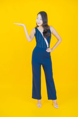 Portre güzel Asyalı kadın gülümsüyor. Renkli arka planda hareket var.