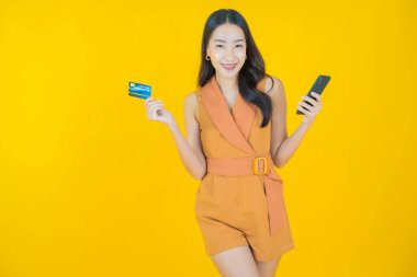 Güzel bir Asyalı kadının portresi. Renkli kredi kartıyla gülüyor.