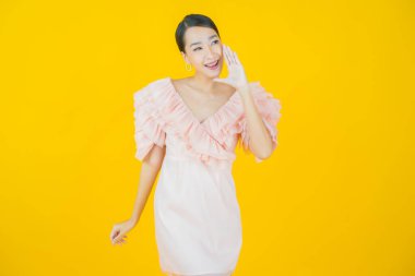 Portre güzel Asyalı kadın gülümsüyor. Renkli arka planda hareket var.