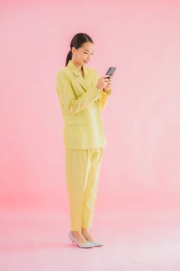 Güzel Asyalı iş kadını portresi. Arka planda kahve fincanı ve akıllı cep telefonu kullanıyor.