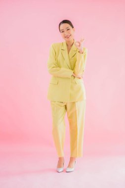 Portre güzel Asyalı genç iş kadını pembe arka planda gülümsüyor