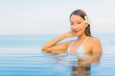 Güzel bir Asyalı kadın portresi. Rahat ol. Yüzme havuzu etrafında gülümse.