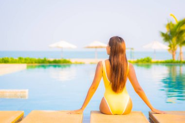 Güzel bir Asyalı kadın portresi. Rahatlayın, gülümseyin. Tatil için oteldeki yüzme havuzunun keyfini çıkarın.