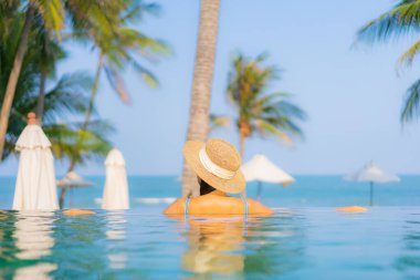 Güzel bir Asyalı kadın portresi. Rahatlayın. Yüzme havuzunun, deniz kenarındaki okyanus manzarasının keyfini çıkarın.