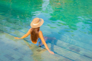 Güzel bir Asyalı kadın portresi. Rahatlayın. Yüzme havuzunun, deniz kenarındaki okyanus manzarasının keyfini çıkarın.