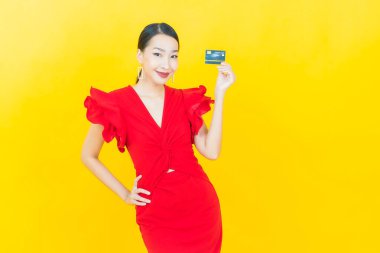 Güzel bir Asyalı kadının portresi. Renkli kredi kartıyla gülüyor.