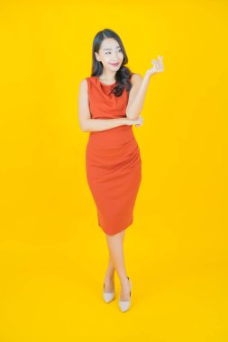 Portre güzel Asyalı kadın gülümsüyor. Renkli arka planda hareket var.