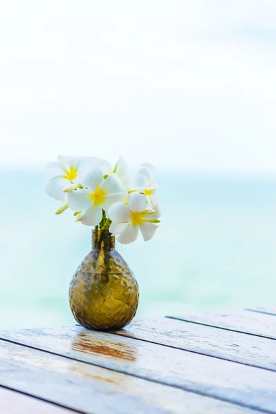 Kwiaty w wazonie na drewnianym stole — Zdjęcie stockowe