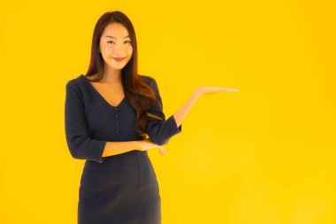 İzole edilmiş sarı arka planda hareketli güzel Asyalı kadın portresi.