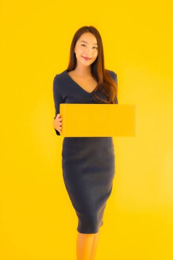 Karton paketli güzel Asyalı kadın, sarı izole edilmiş arka planda nakliyeye hazır.