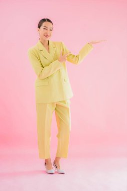 Portre güzel Asyalı genç iş kadını pembe arka planda gülümsüyor