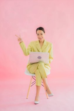 Güzel Asyalı iş kadını portresi renk arkaplanda bilgisayar bilgisayarı kullanıyor