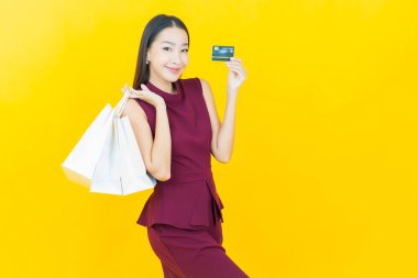 Portre güzel Asyalı kadın tebessümü ile renk arka planında alışveriş torbası