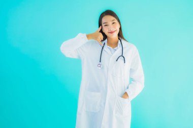 Güzel bir Asyalı doktor portresi. Klinik ya da hastane için cep telefonu kullanıyor.