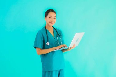 Mavi izole arka planda dizüstü bilgisayarı olan güzel Asyalı doktor kadın portresi.