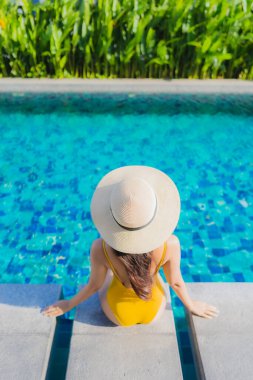 Güzel bir Asyalı kadın portresi. Rahatlayın. Keyifli bir tatil için oteldeki yüzme havuzunda mutlu bir gülümseme.