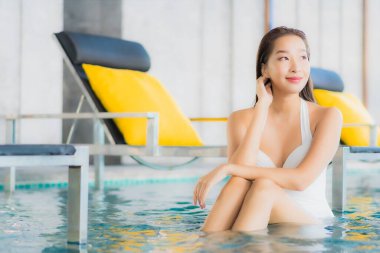 Güzel bir Asyalı kadının portresi rahatlatıcı. Tatilde otel havuzunda yüzme havuzunda gülümse.