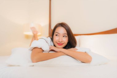 Güzel bir Asyalı kadının portresi. Gülümse. Yatak odasında rahatla.