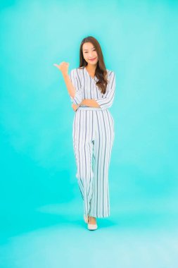 Asyalı güzel bir kadının portresi mavi izole edilmiş arka planda gülümsüyor.