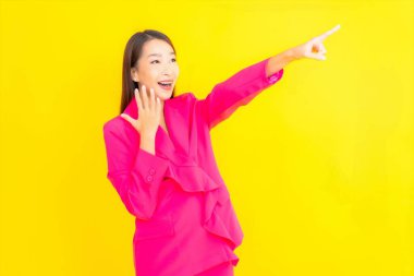 Güzel bir Asyalı kadın sarı arka planda gülümsüyor.