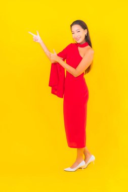 Güzel bir Asyalı kadın portresi. Sarı izole edilmiş arka planda hareketli gülümsüyor.