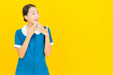 Güzel bir Asyalı kadın portresi ve sarı arka planda hareketli bir gülümseme.