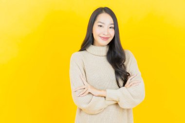 Portre güzel Asyalı kadın gülümsüyor. Renkli arka planda hareket var.